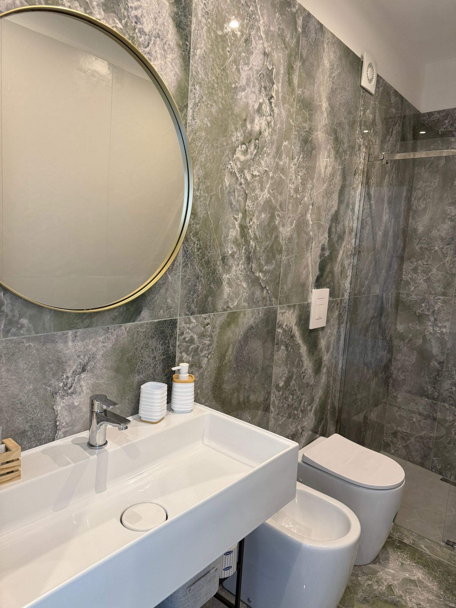 Suite Emerald — bagno con marmo verde onice e specchio dorato